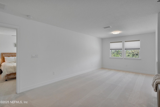 carpeted empty room with a textured ceiling