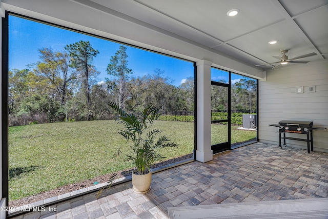 unfurnished sunroom with ceiling fan