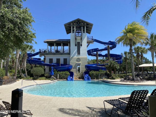 view of swimming pool with a water slide and a patio area