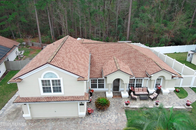 view of front facade featuring a garage, outdoor lounge area, and a patio area