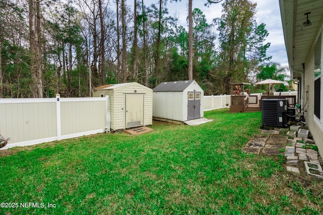 view of yard with cooling unit, a deck, and a storage unit