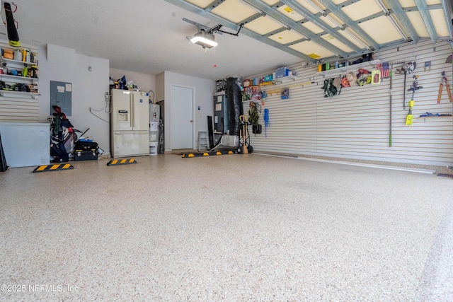 garage with a garage door opener, electric panel, and white fridge with ice dispenser