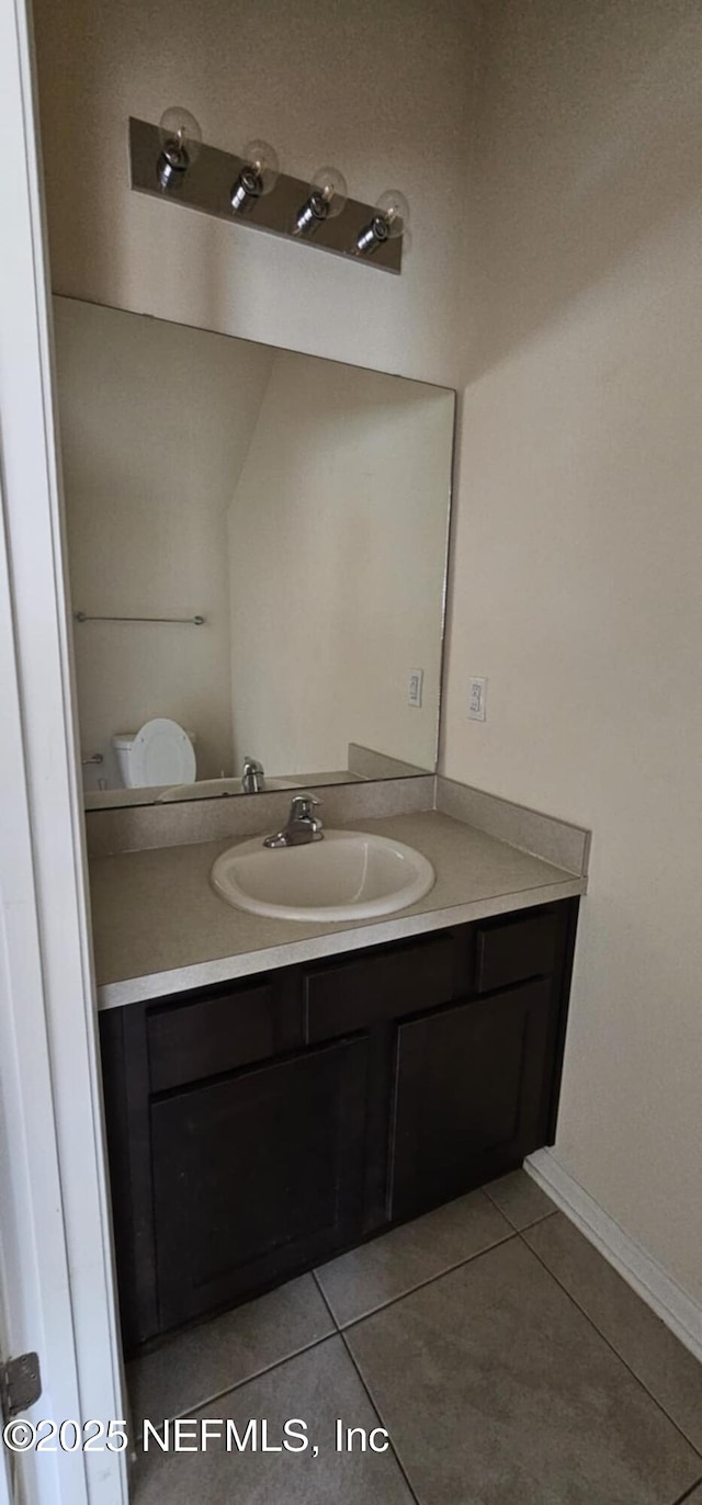 bathroom featuring vanity, tile patterned floors, and toilet