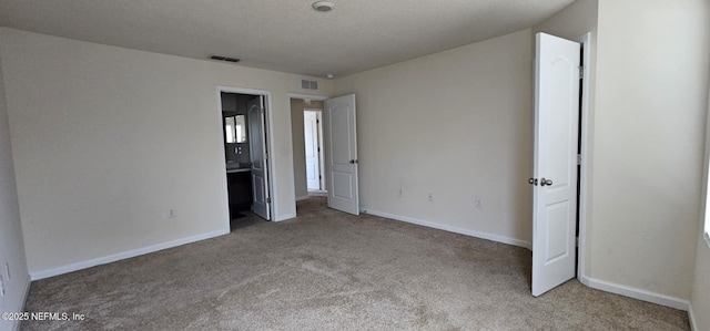 unfurnished bedroom featuring light colored carpet and a textured ceiling