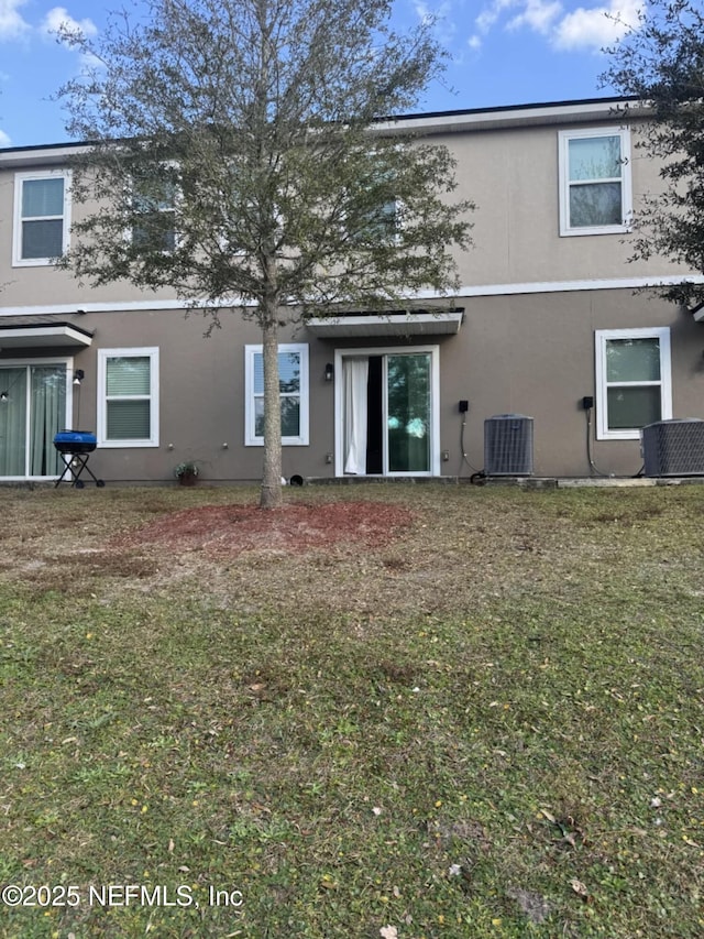 back of property featuring a yard and central AC