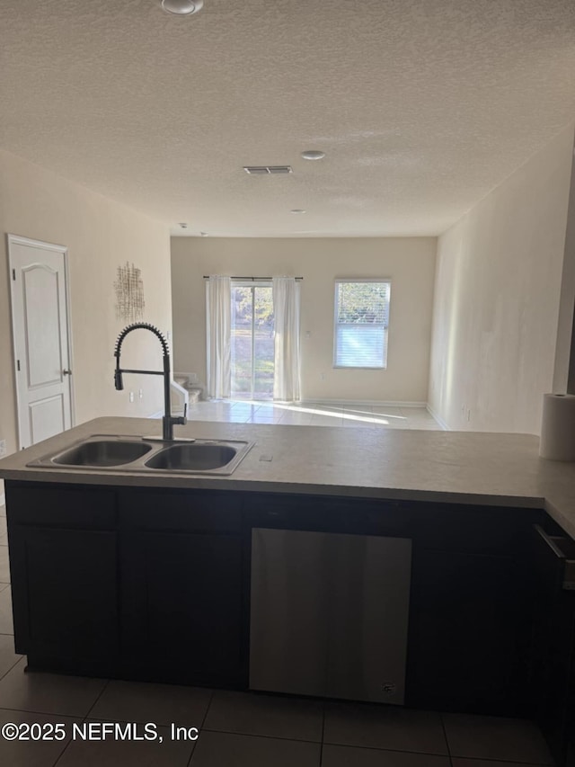 kitchen with sink, light tile patterned floors, and a textured ceiling