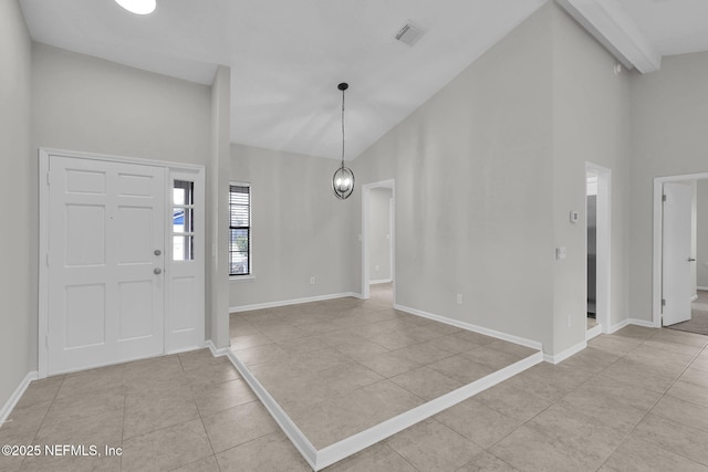 tiled entrance foyer featuring beamed ceiling, high vaulted ceiling, and an inviting chandelier