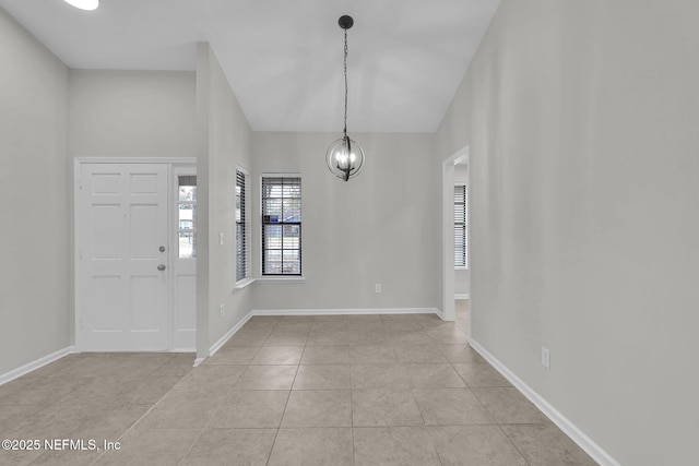 tiled foyer entrance featuring a notable chandelier