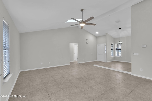 unfurnished living room featuring ceiling fan with notable chandelier, a skylight, high vaulted ceiling, and light tile patterned flooring