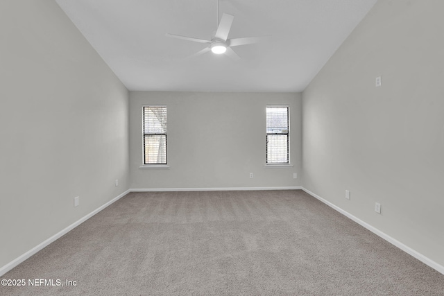 carpeted empty room with ceiling fan, plenty of natural light, and lofted ceiling