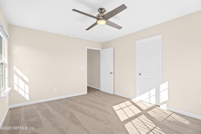 unfurnished room with light colored carpet and ceiling fan