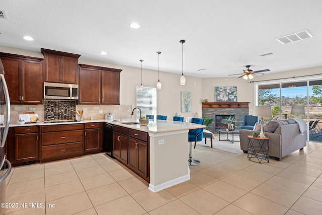 kitchen with pendant lighting, tasteful backsplash, black dishwasher, a breakfast bar area, and sink