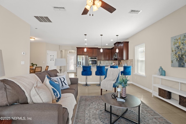 living room with light tile patterned flooring, ceiling fan, and sink