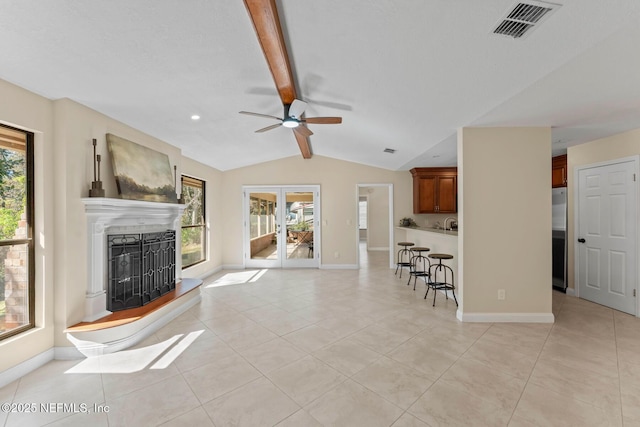 unfurnished living room featuring vaulted ceiling with beams, a wealth of natural light, ceiling fan, and light tile patterned floors