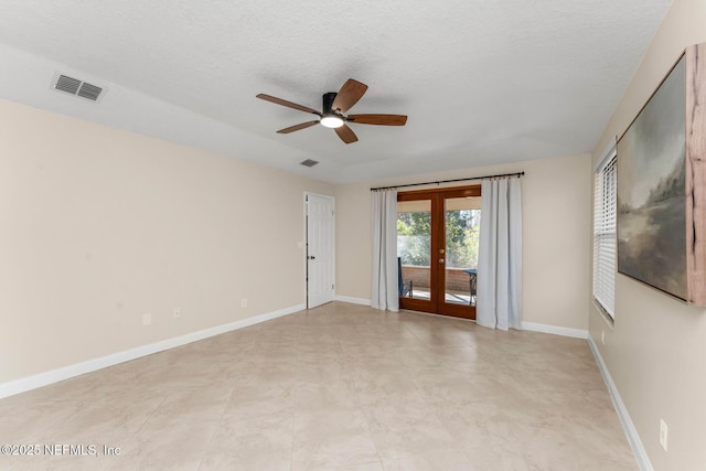 spare room featuring french doors, ceiling fan, and a textured ceiling