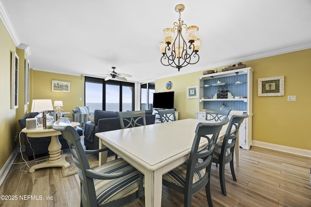 dining room with crown molding, light hardwood / wood-style flooring, floor to ceiling windows, and ceiling fan with notable chandelier