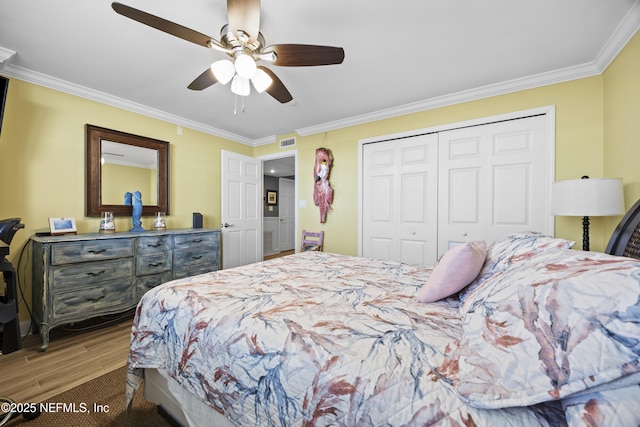 bedroom with ornamental molding, hardwood / wood-style floors, ceiling fan, and a closet