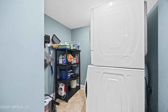 laundry area with light tile patterned floors and stacked washer and clothes dryer