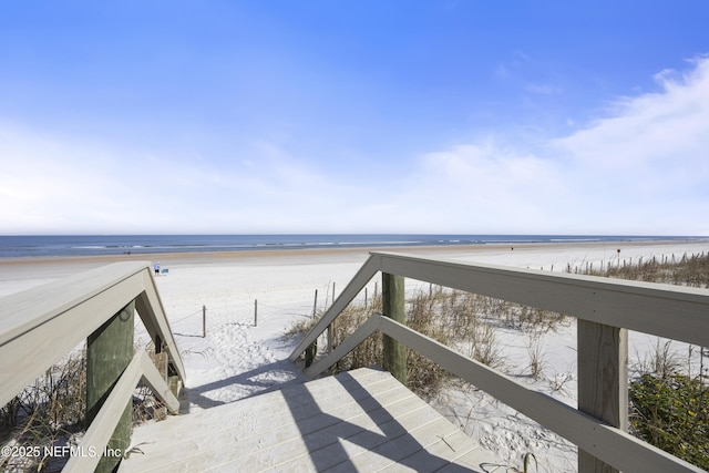 view of property's community with a water view and a view of the beach