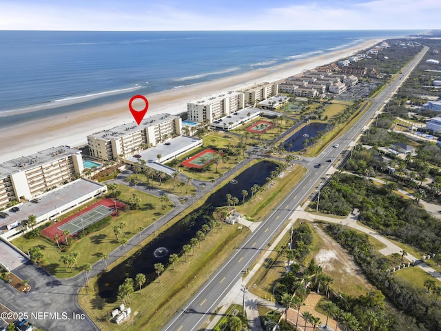 birds eye view of property with a water view and a beach view