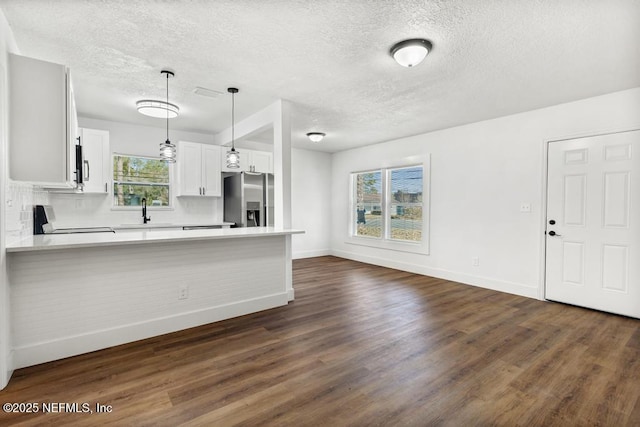 kitchen with decorative light fixtures, sink, white cabinets, kitchen peninsula, and stainless steel appliances