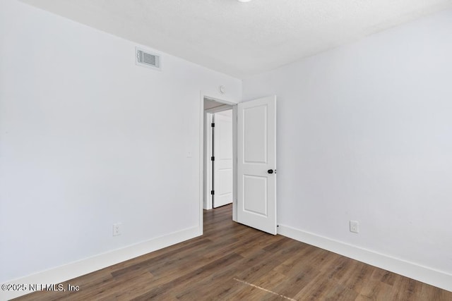 empty room featuring dark hardwood / wood-style flooring