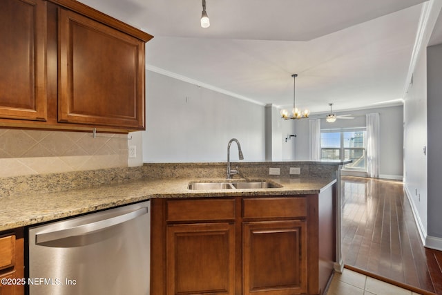 kitchen with dishwasher, sink, backsplash, crown molding, and light stone countertops