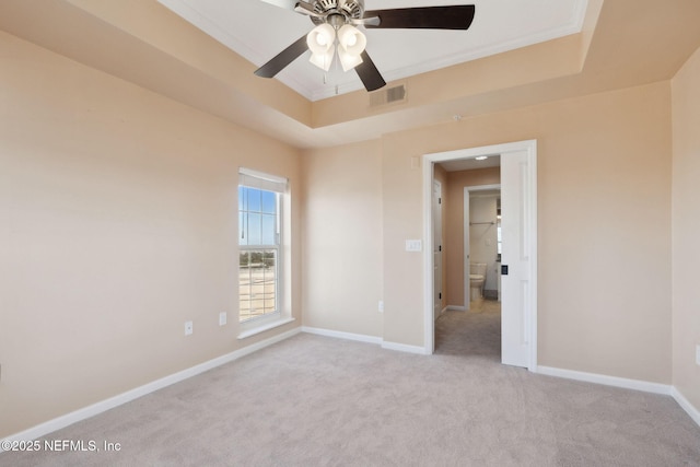 unfurnished room featuring crown molding, a tray ceiling, light colored carpet, and ceiling fan