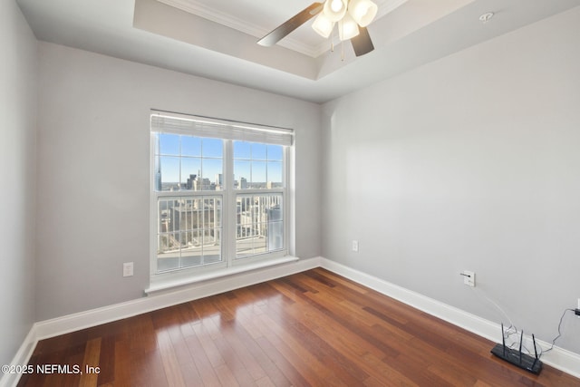 spare room featuring hardwood / wood-style floors, a tray ceiling, and ceiling fan