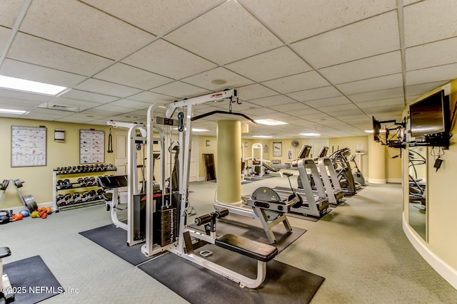 workout area featuring carpet floors and a paneled ceiling