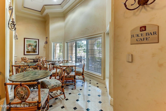 dining area with crown molding and a high ceiling