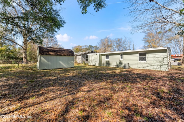 rear view of property featuring a storage shed