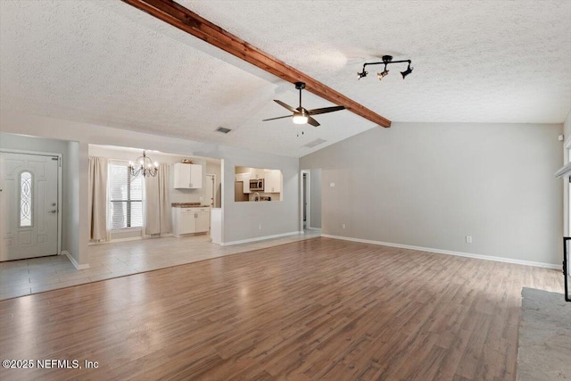 unfurnished living room with vaulted ceiling with beams, ceiling fan with notable chandelier, light hardwood / wood-style flooring, and a textured ceiling