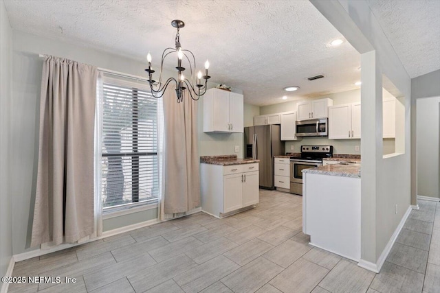 kitchen with pendant lighting, an inviting chandelier, stainless steel appliances, light stone countertops, and white cabinets