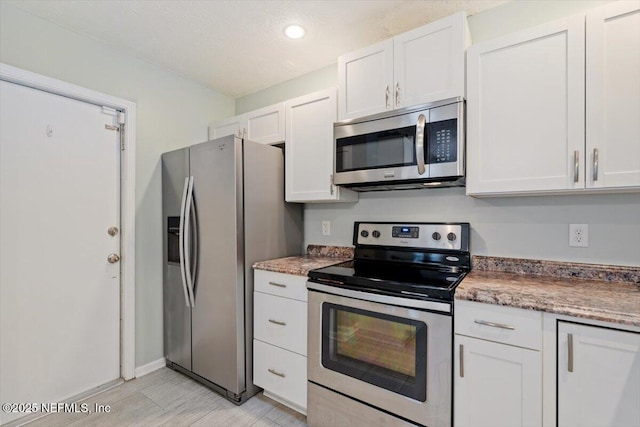 kitchen featuring white cabinets and appliances with stainless steel finishes