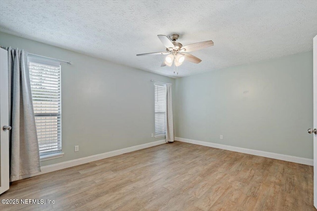 empty room featuring a textured ceiling, light hardwood / wood-style flooring, and ceiling fan