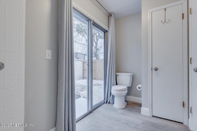 bathroom featuring hardwood / wood-style flooring, toilet, and a textured ceiling