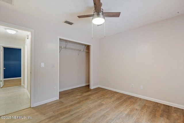 unfurnished bedroom featuring light hardwood / wood-style floors, a closet, and ceiling fan