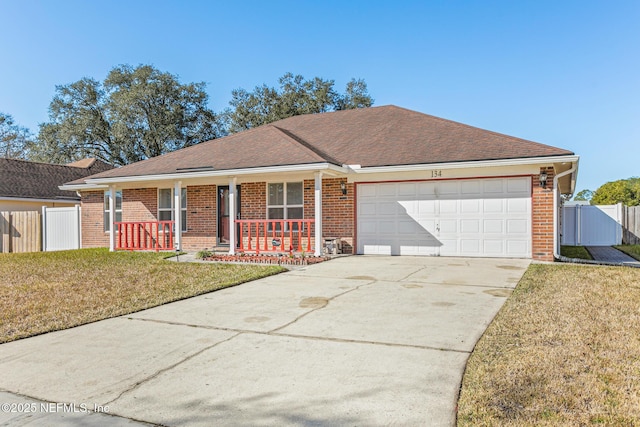 ranch-style house featuring a porch, a garage, and a front yard