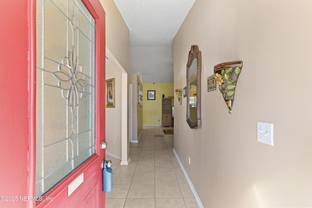 corridor with light tile patterned floors and a textured ceiling