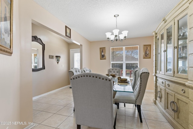 tiled dining area with a textured ceiling and an inviting chandelier