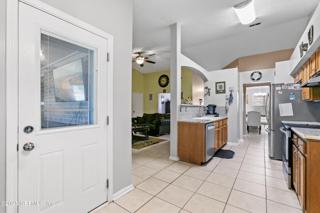 kitchen featuring sink, a textured ceiling, light tile patterned floors, ceiling fan, and stainless steel appliances