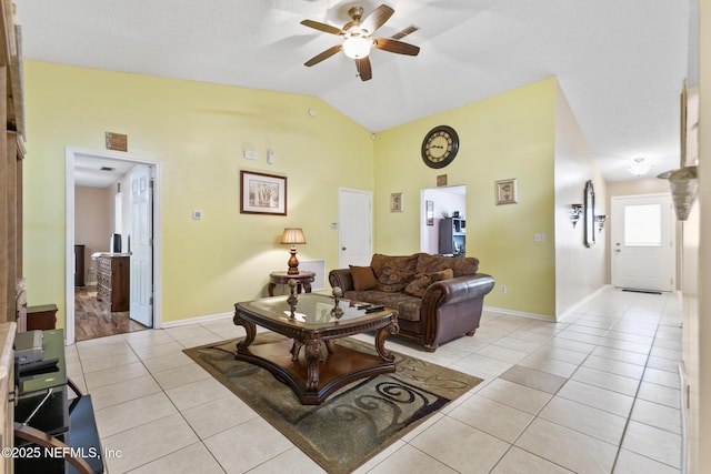 living room featuring lofted ceiling, light tile patterned floors, and ceiling fan