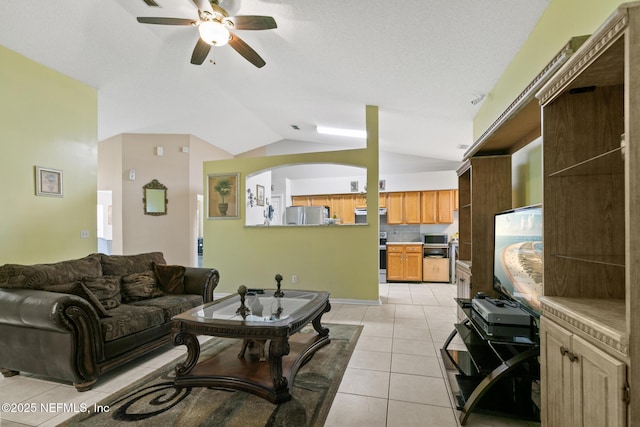 tiled living room with vaulted ceiling and ceiling fan