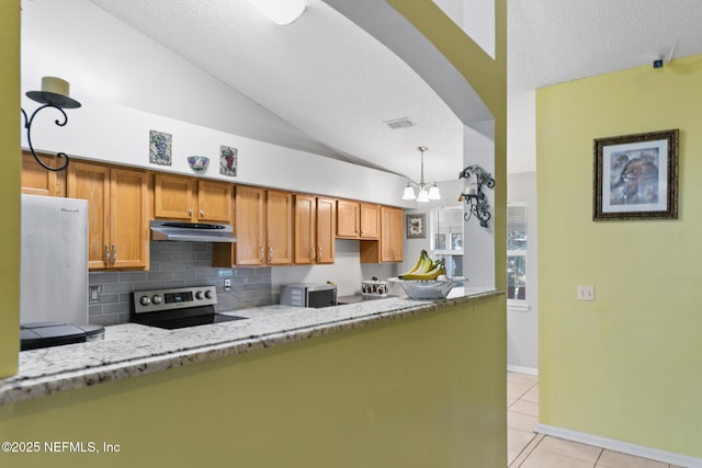 kitchen featuring light tile patterned flooring, appliances with stainless steel finishes, decorative backsplash, light stone counters, and kitchen peninsula