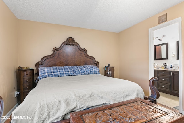 bedroom featuring ensuite bath and a textured ceiling