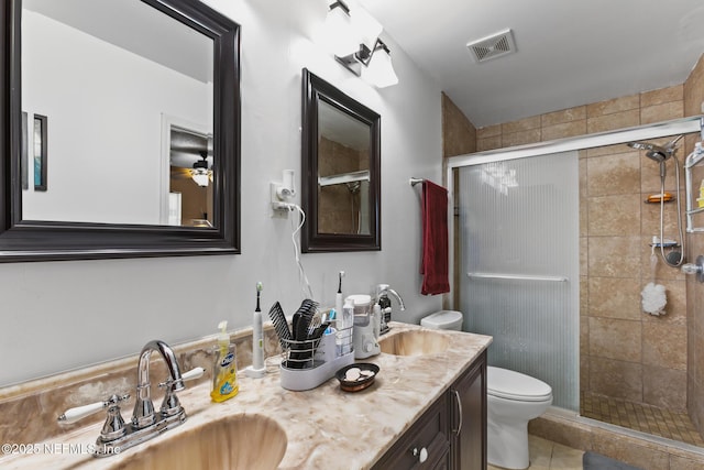 bathroom with vanity, tile patterned flooring, toilet, and walk in shower