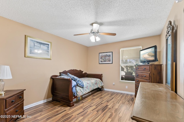 bedroom with ceiling fan, a textured ceiling, and light wood-type flooring