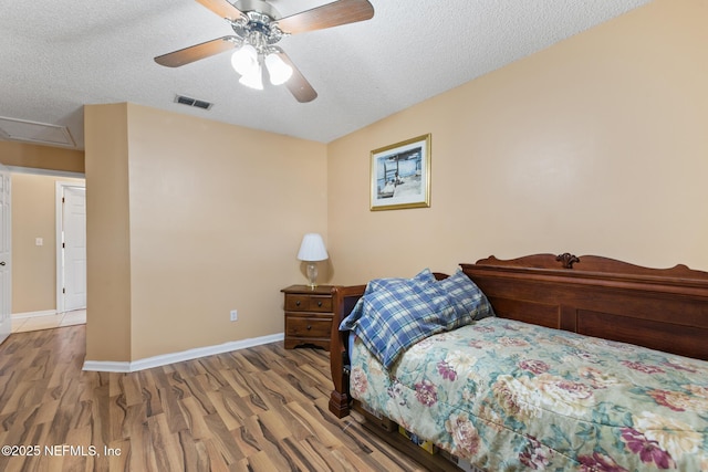 bedroom featuring wood-type flooring, ceiling fan, and a textured ceiling