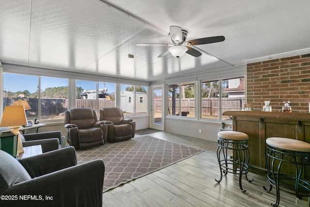 sunroom featuring ceiling fan and plenty of natural light